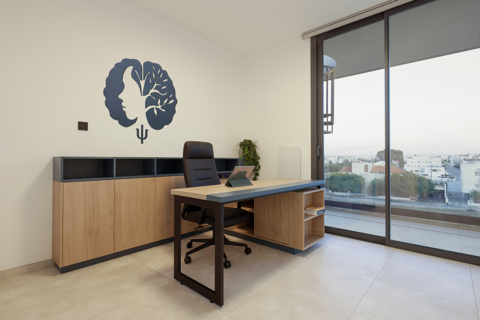 Psychologist consultation office in Nicosia by KK Interior Design with desk, storage cabinetry, and natural daylight